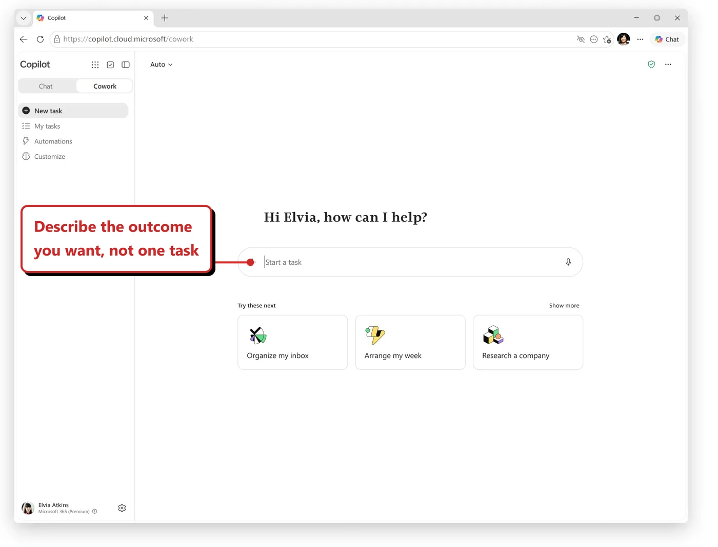 Official Microsoft screenshot of the Cowork home page. The greeting reads Hi Elvia, how can I help? with a Start a task box and suggested prompts Organize my inbox, Arrange my week and Research a company. Callout: “Describe the outcome you want, not one task”